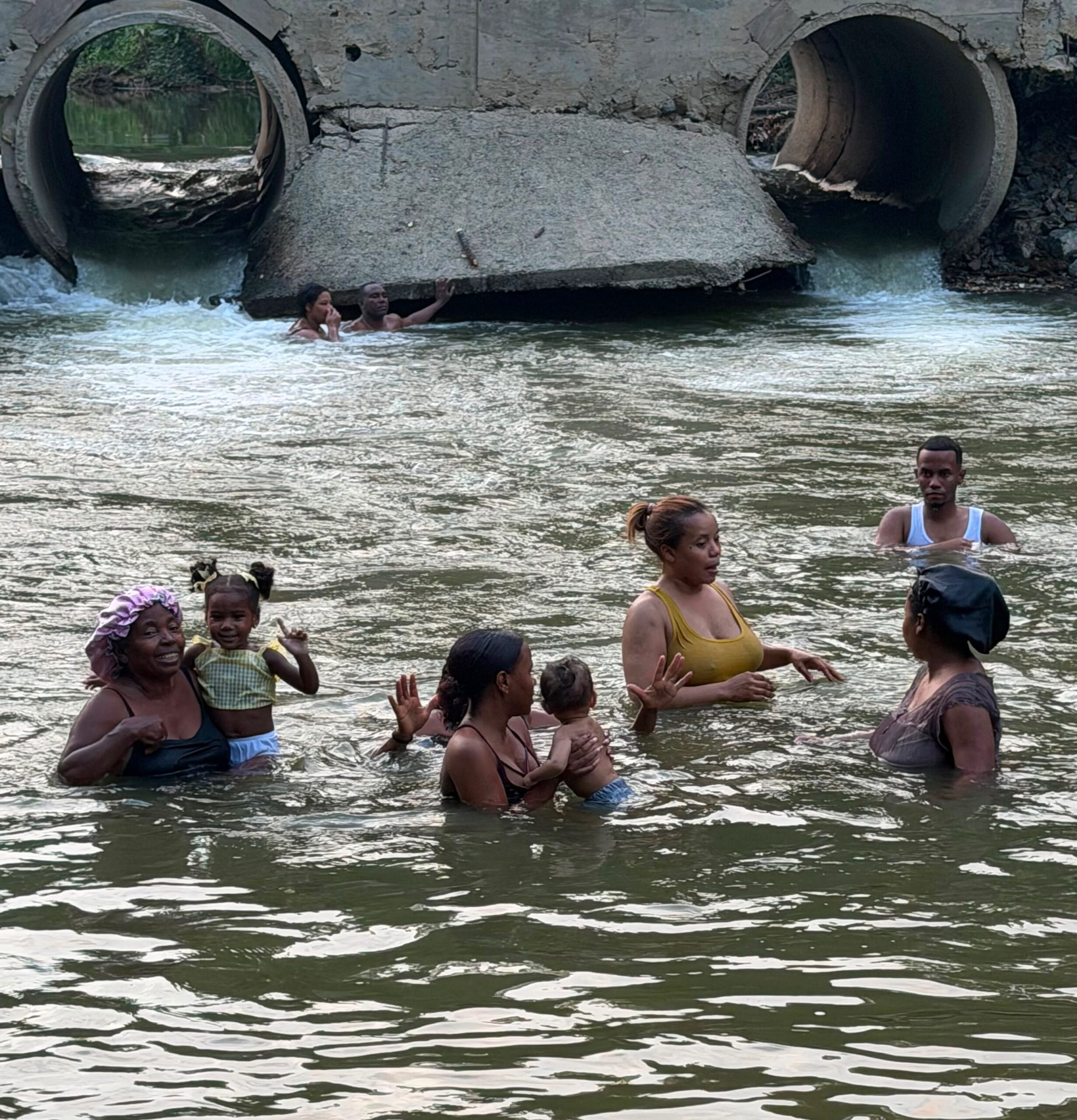 Extended family swimming in the Río Ozama in Yamasá